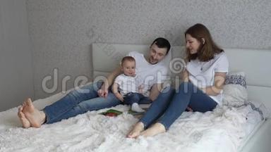 年轻的家庭在家里睡觉。 <strong>爸爸妈妈</strong>和他们的女儿一起玩